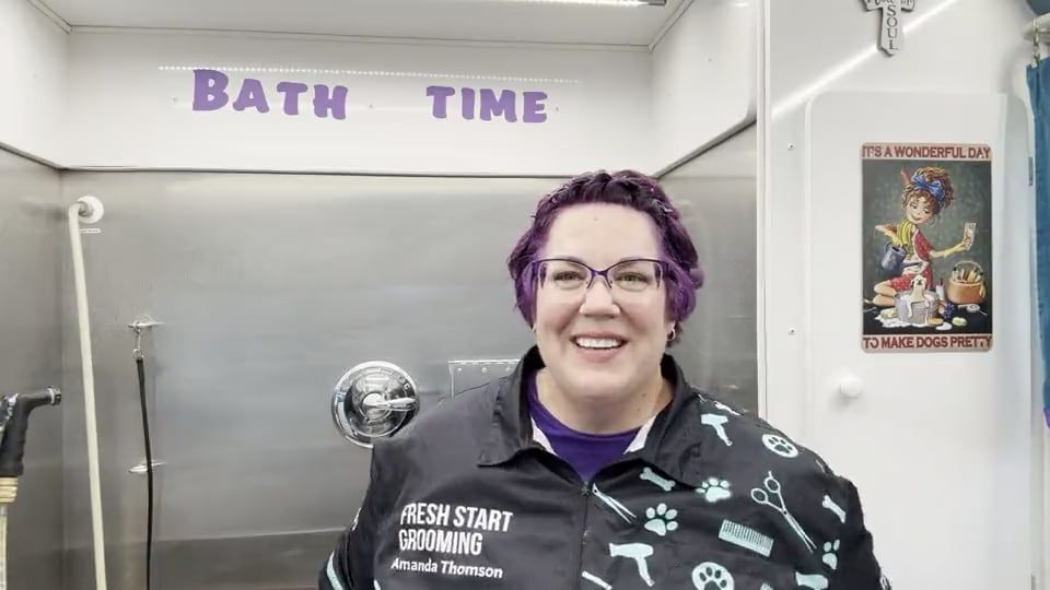 Amanda in the trailer's bath stall, explaining why shaving your dog in the Texas heat can backfire