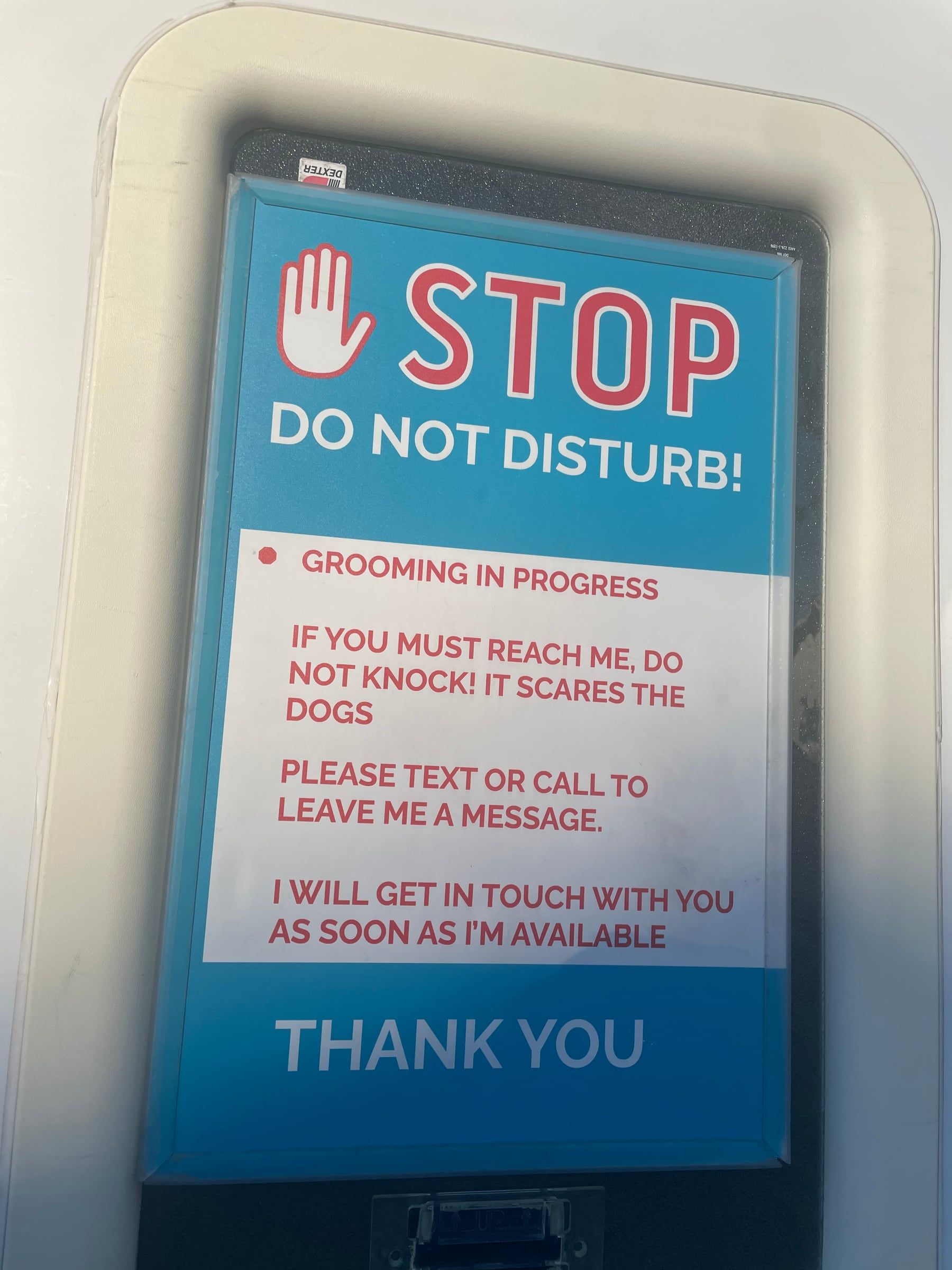 The Stop, Do Not Disturb sign on the trailer door: grooming in progress, please text or call instead of knocking
