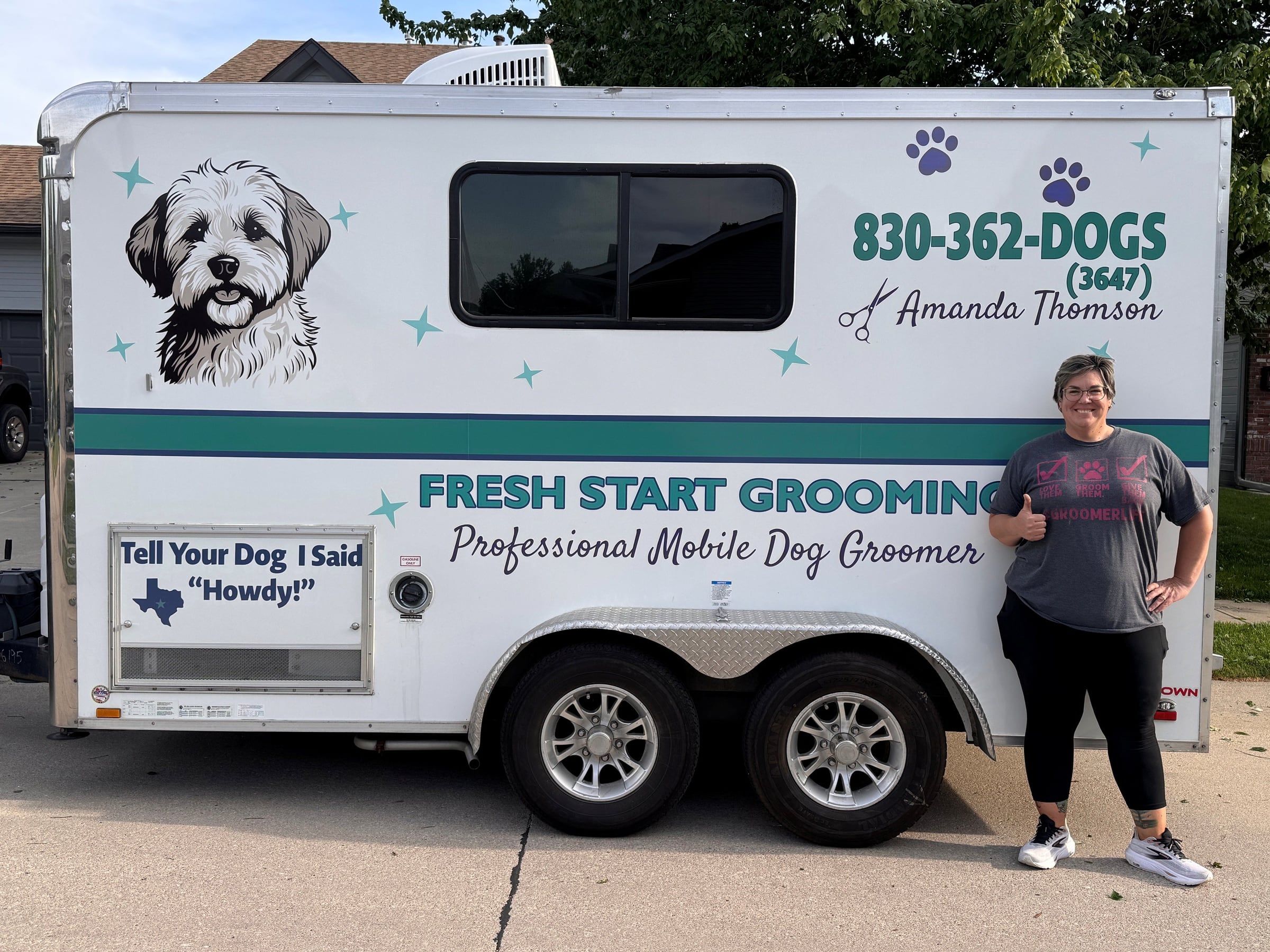 Amanda giving a thumbs up beside the Fresh Start Grooming trailer